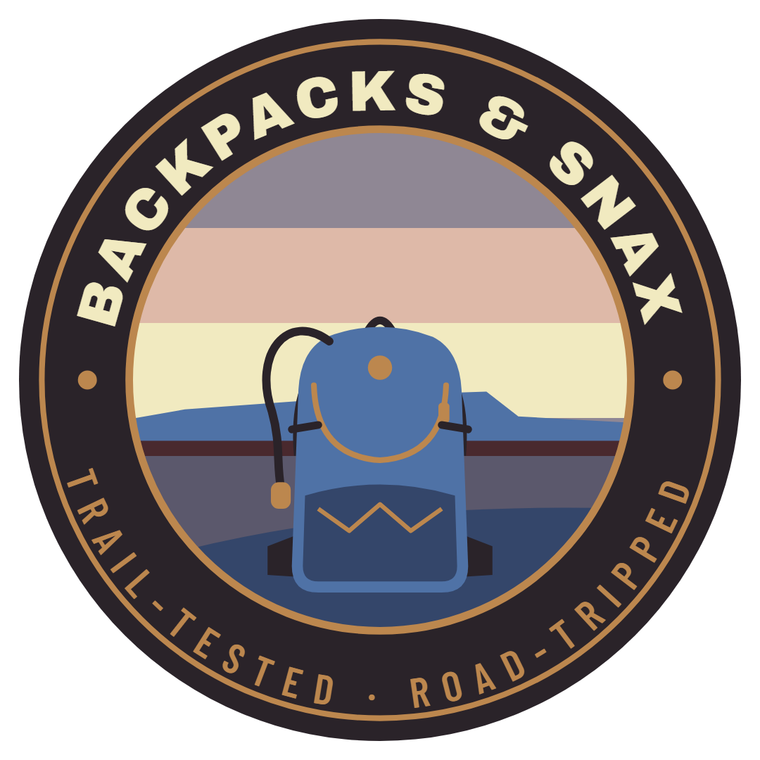Backpacks and Snax trailhead badge: a blue backpack in front of a sunset